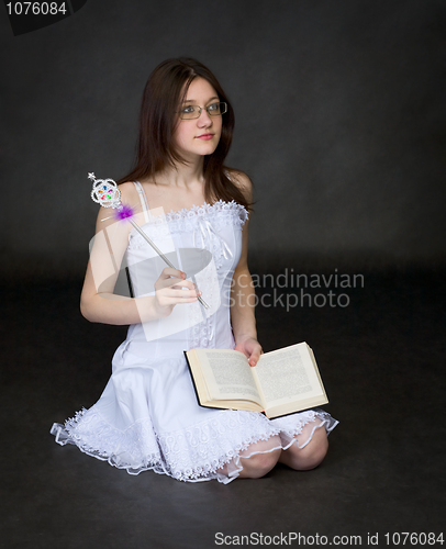 Image of Girl - the magician with the book sits on black