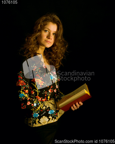 Image of Beautiful girl against a dark background with book