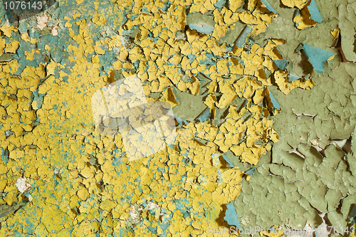 Image of Old damaged yellow paint on a concrete wall