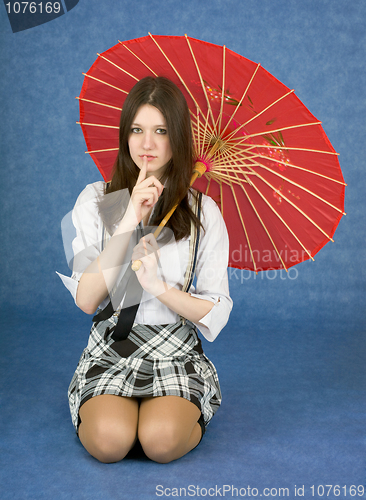 Image of Young woman with umbrella on blue background