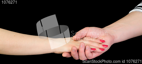 Image of Female hand in a man's hand on a black