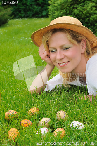 Image of Young woman and easter eggs on the grass - Easter time