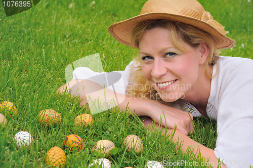 Image of Young woman and easter eggs on the grass - Easter time