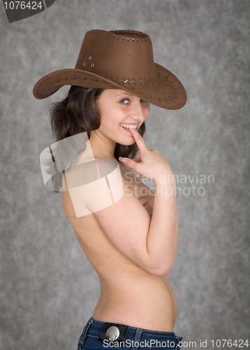 Image of Beautiful playful young woman in cowboy hat on grey background