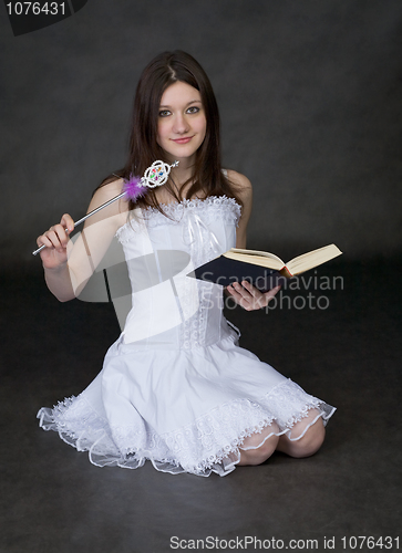 Image of Girl - fairy in a white dress with magic wand and book