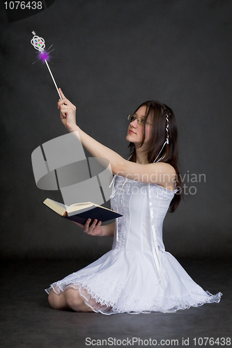 Image of Girl in suit of the fairy with magic wand on black background