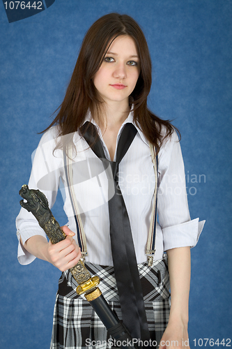 Image of Beautiful girl standing on blue background with japanese sword