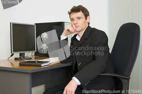 Image of Young businessman sits at table