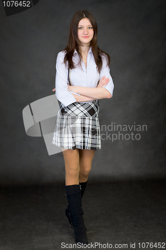 Image of Beautiful girl in a skirt standing on black background