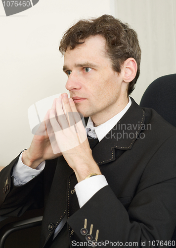 Image of Guy in black jacket sits having combined hands