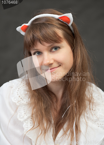 Image of Smiling beautiful girl in white chemise and with glamour ears