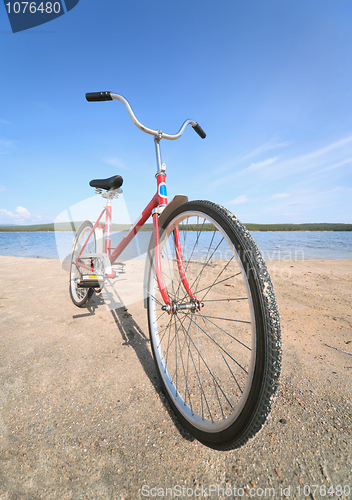 Image of Old red bicycle photographed on beach