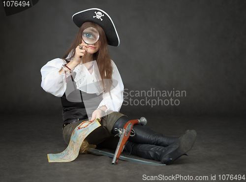 Image of Beautiful girl the pirate looks through a magnifier