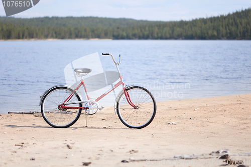 Image of Old red bicycle photographed on beach