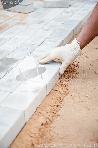 Image of Installation of brick platform - laying bricks on sand