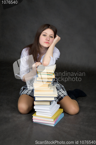 Image of Missing girl has leant the elbows on the pile of books