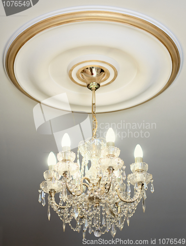 Image of Big electric chandelier hanging down from a ceiling