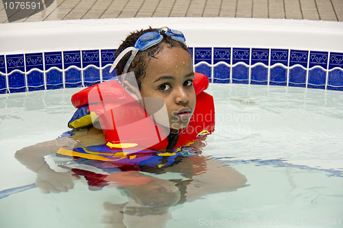 Image of A young boy soaking in a hot tub