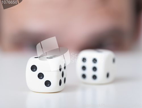 Image of Two playing cubes against man face