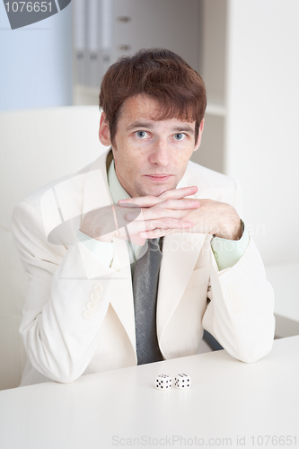 Image of Young businessman sits at office on workplace