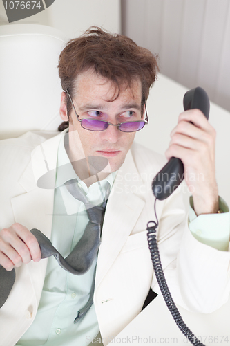 Image of Businessman emotionally speaks on phone at office