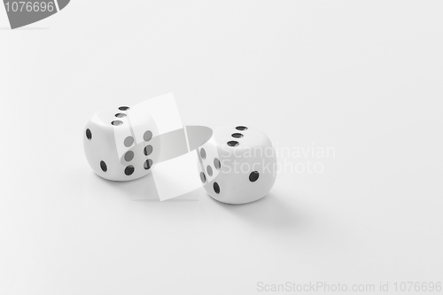 Image of Two playing bones lie on white table