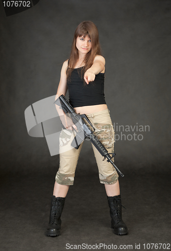 Image of Young woman with rifle in hand shows on us