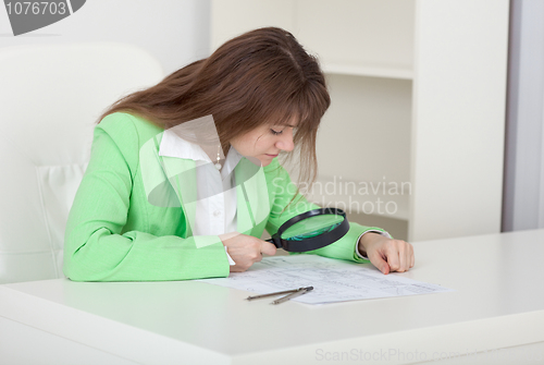 Image of Girl studies drawings by means of magnifier