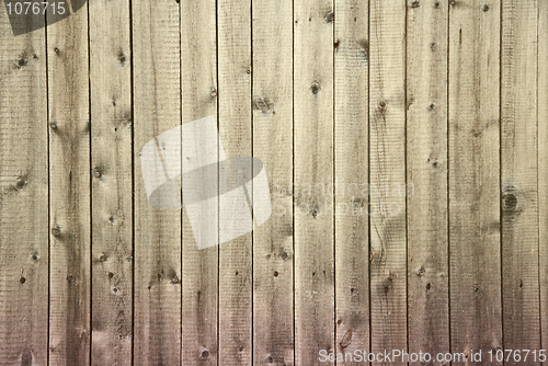 Image of Old dirty wooden fence begun to rot from below background