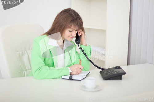 Image of Secretary speaks by phone and does records