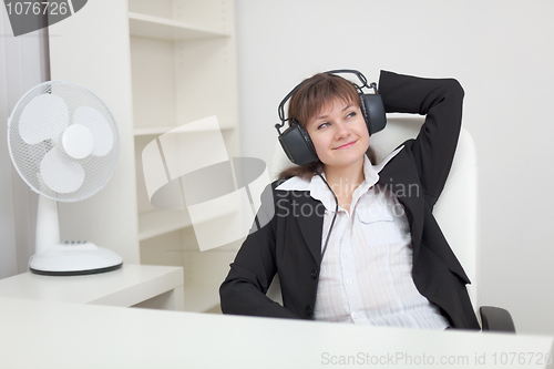 Image of Woman listens to music in ear-phones