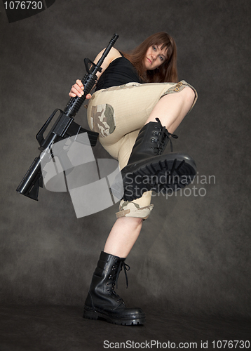 Image of Furious woman with rifle in hands kicks