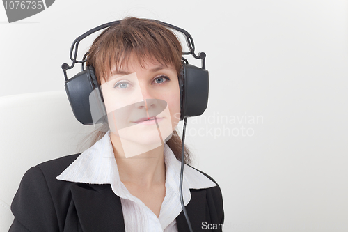 Image of Portrait of young woman with big ear-phones on head