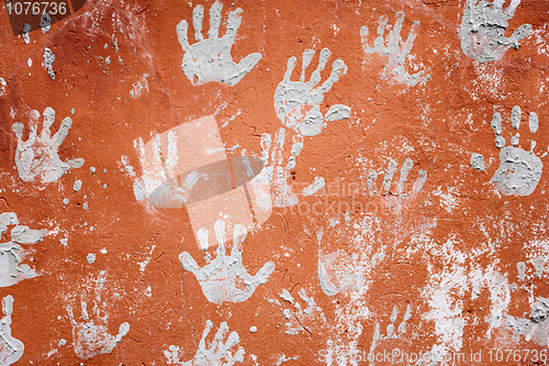 Image of Concrete red wall with prints of hands