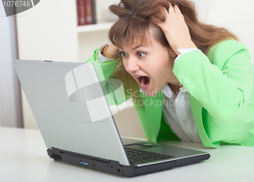 Image of Young girl shouts looking in laptop screen