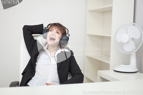 Image of Girl funny sings sitting in an armchair at office