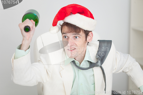 Image of Young guy in christmas hat brawls with bottle in hand