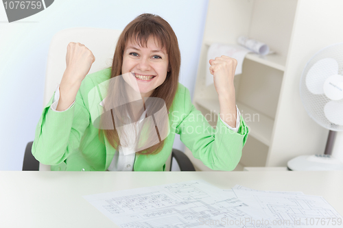 Image of Emotional girl rejoices sitting in an armchair