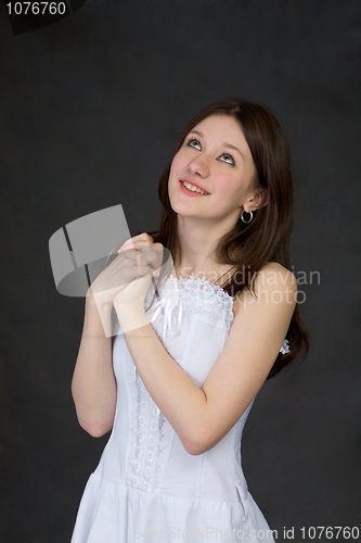 Image of Pensive beautiful girl in white dress on black background