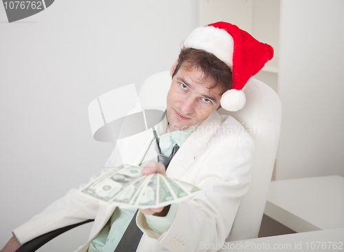 Image of Businessman in white suit and Christmas cap gives us money