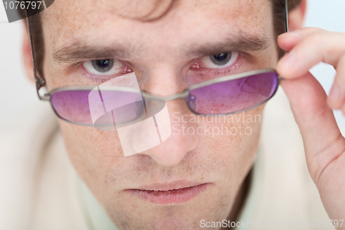 Image of Man seriously and strictly looks at us over glasses