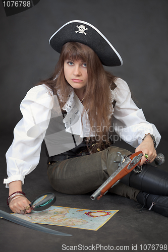 Image of Woman in costume of pirate with sea map and magnifier glass