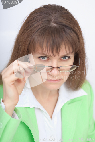 Image of Serious woman - teacher looks at us over glasses