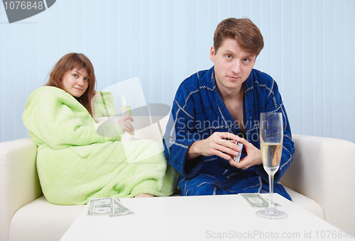Image of Men drink sparkling wine and play on money