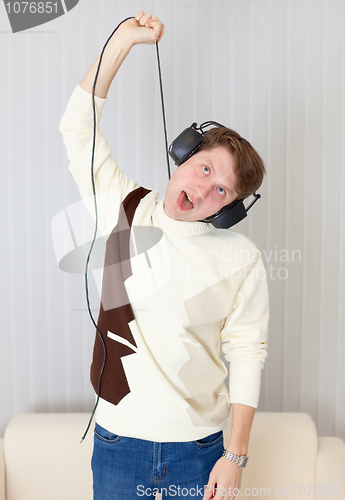 Image of Young man smothers itself wire from stereo-ear-phones