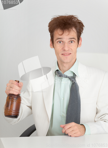 Image of Young man at office with a beer bottle