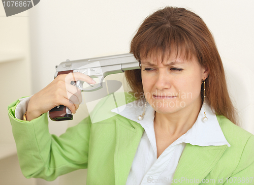 Image of Woman - suicide shoots to itself at head from a pistol