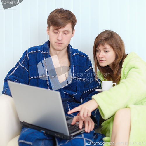 Image of Husband and wife at house on sofa with laptop