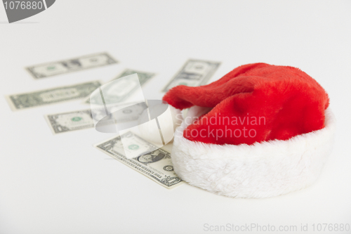 Image of Christmas cap and dollars on white background