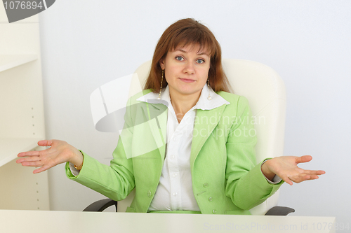 Image of Young business woman with astonishment shrugs shoulders